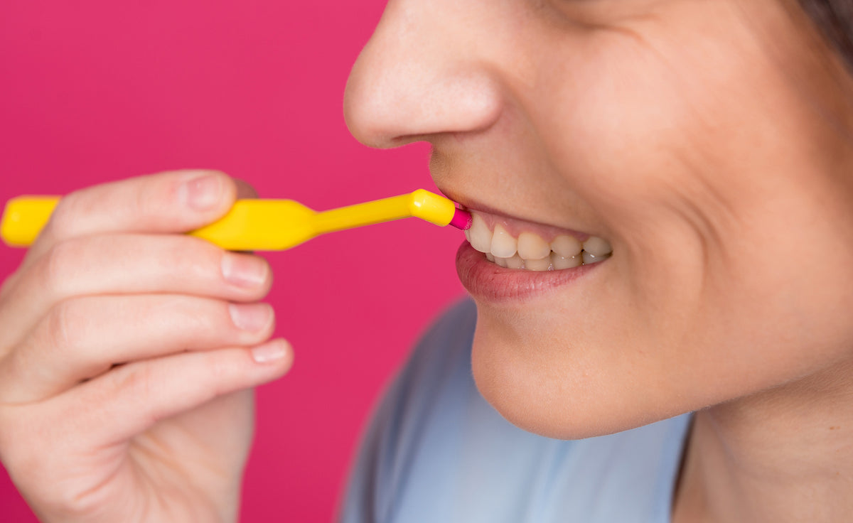 Single tuft toothbrush - young woman with single tufted toothbrush