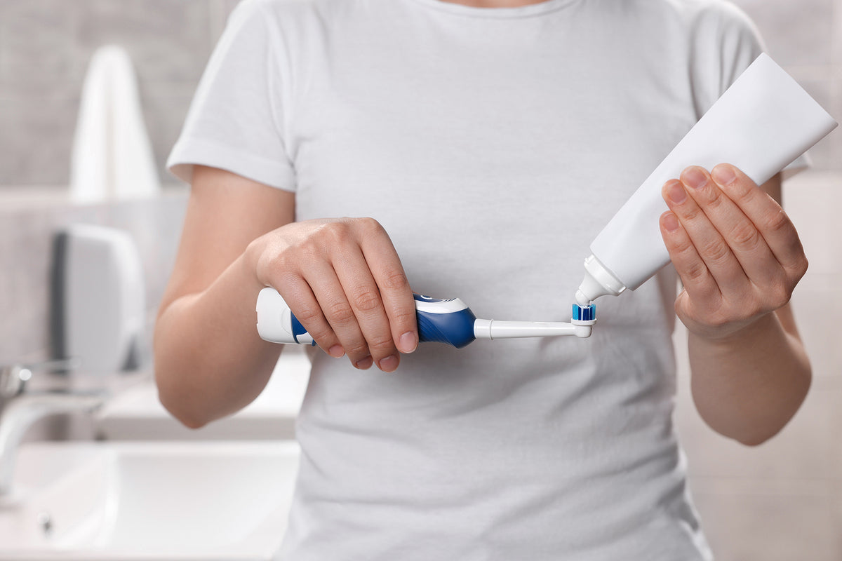 woman squeezing toothpaste