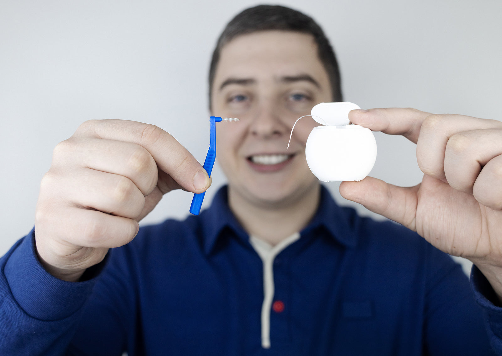 dental care products - man holding Interdental Brush and dental floss