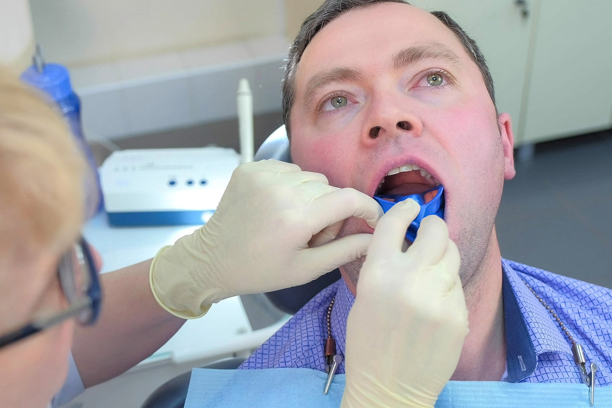 dental products online - Dentist puts mouth guard with fluoride gel
